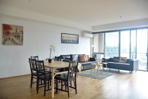 a living room with a table and a couch at RiverView Spacious 3BR2Bath2Car WifiPoolGym Crown in Melbourne