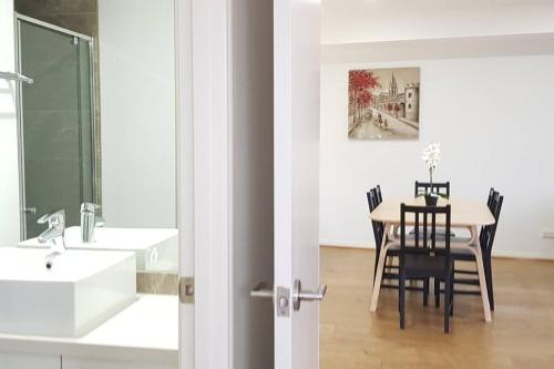 Una cocina y un comedor con una mesa y un fregadero. en RiverView Spacious 3BR2Bath2Car WifiPoolGym Crown, en Melbourne