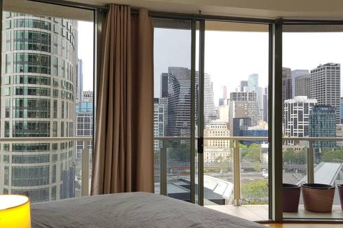 a bedroom with a view of a city skyline at RiverView Spacious 3BR2Bath2Car WifiPoolGym Crown in Melbourne