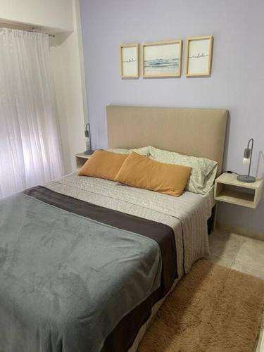 Dormitorio con cama con almohada naranja en Amplio depto Mogotes en Mar del Plata