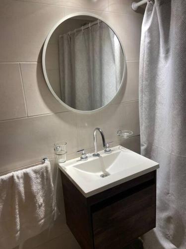 a bathroom with a sink and a mirror at Amplio depto Mogotes in Mar del Plata