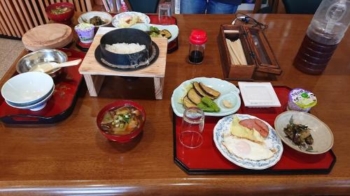 a wooden table with plates of food on it at Bandai in Tokamachi
