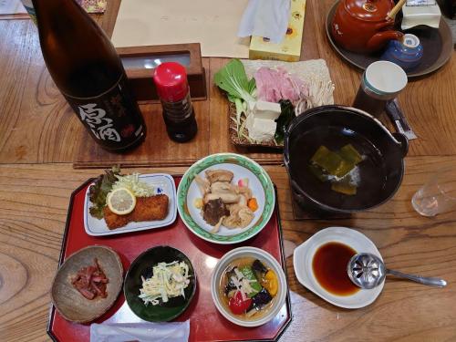 a table topped with dishes of food and a drink at Bandai in Tokamachi