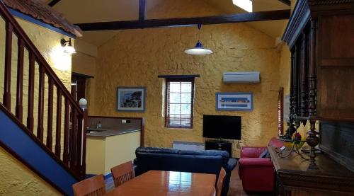 a living room with a table and a kitchen at The Camperdown Mill in Camperdown