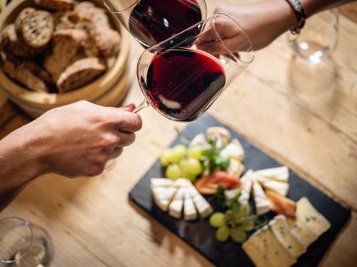 a person pouring a glass of wine over a plate of food at Dorfgasthof Adler in Mellau
