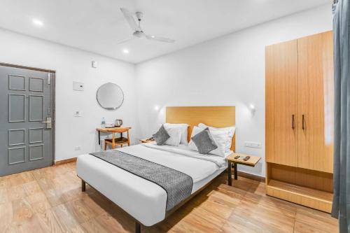 a bedroom with a large white bed and a door at Rohaan Inn - UPAR Hotels Ashok Nagar in Chennai