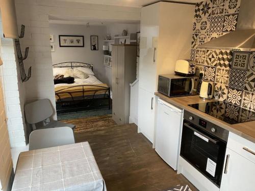 a small kitchen with a bed in a bedroom at The studio (Hideaway) Dog friendly in Matlock