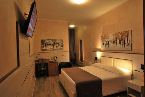 um quarto de hotel com uma cama e uma televisão de ecrã plano em Hotel Lenotel em Leno