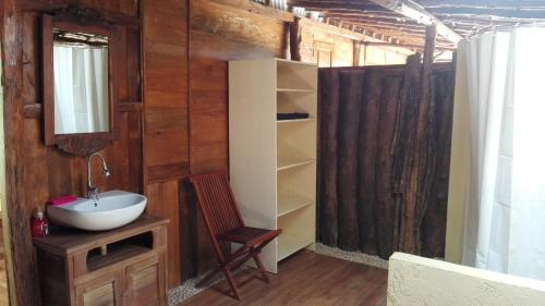 baño con lavabo y pared de madera en Havana Horses Lodge en Tingkirtengah