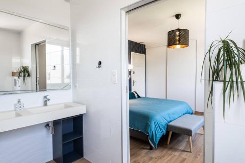 een badkamer met een bed, een wastafel en een spiegel bij L'écrin de la Cité, Coeur de Vignes in Carcassonne