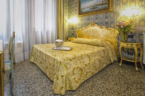 a bedroom with a bed with a yellow bedspread at Hotel Noemi in Venice