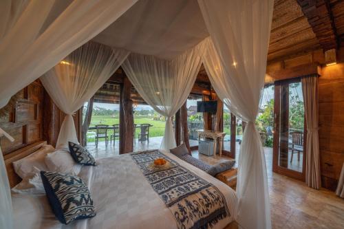 a bedroom with a bed with a canopy at Villa Lignea in Tampaksiring