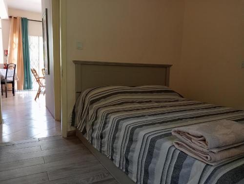 a bedroom with a bed with a striped blanket on it at Chetty Tourist Residence in Pereybere
