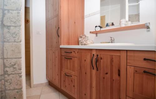 een badkamer met een wastafel en een spiegel bij Awesome Home In Rochefort Du Gard With 4 Bedrooms, Wifi And Outdoor Swimming Pool in Rochefort-du-Gard