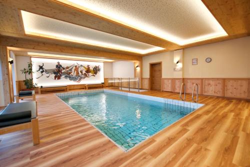 einen Pool in einem Raum mit einem Gemälde an der Wand in der Unterkunft Hotel St. Georg in Zell am See