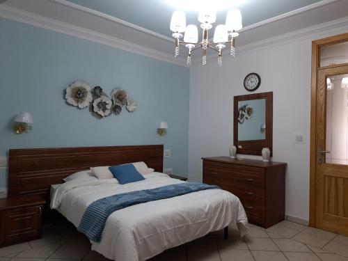 a bedroom with a bed and a mirror and a chandelier at Seafront Apartment in St. Paul's Bay in St Paul's Bay