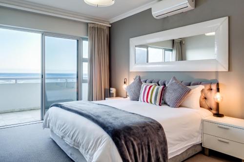 1 dormitorio con cama grande y ventana grande en Dunmore Skies, en Ciudad del Cabo