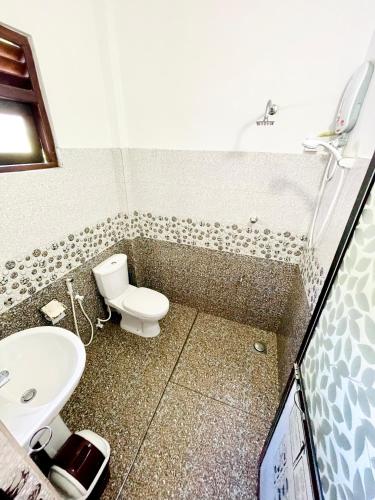 a bathroom with a toilet and a sink at Shan Star Weligama in Weligama