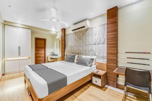 a bedroom with a bed and a desk and a chair at Upar Hotels Cinecity Kodambakkam RAGHAVENDRA MANDAPAM in Chennai
