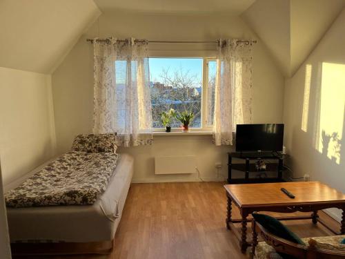 a bedroom with a bed and a window and a table at Dammyr, close to City with parking in Fredrikstad