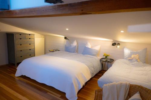 a bedroom with two beds with white sheets at Santa Ana in Westermarkelsdorf