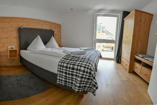 a bedroom with a bed with a black and white blanket at Veranda Appartement Bergblick in Gries im Sellrain