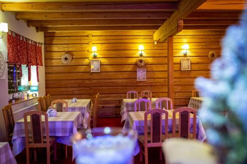 a dining room with tables and chairs with purple table cloth at Czarna Owca in Istebna