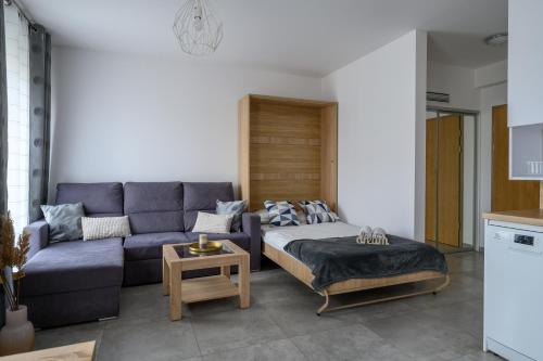 a living room with a couch and a bed at Rent-Apart City Center Narutowicza in Łódź