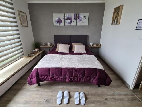 a bedroom with a bed with a purple bedspread at LE COCON DE JADE, LA MER A PERTE DE VUE in Le Havre