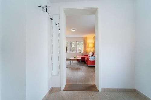 un corridoio che conduce a un soggiorno con divano rosso di Haus Seestern Seestern 3 a Scharbeutz