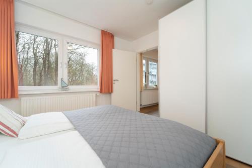 una camera con un letto e due finestre di Haus Seestern Seestern 3 a Scharbeutz