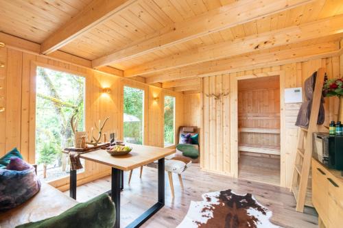 a wooden cabin with a table in a room at Chalet VitaSpa - Whirlpool & Sauna PrivatSpa in Pegnitz