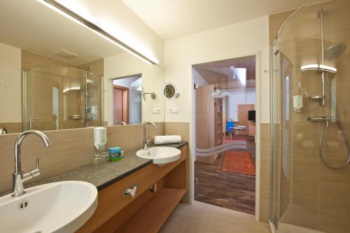 a bathroom with two sinks and a shower at Familien- Sportresort BRENNSEEHOF in Feld am See