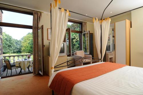 a bedroom with a large bed and a balcony at Kasteel Wurfeld in Maaseik