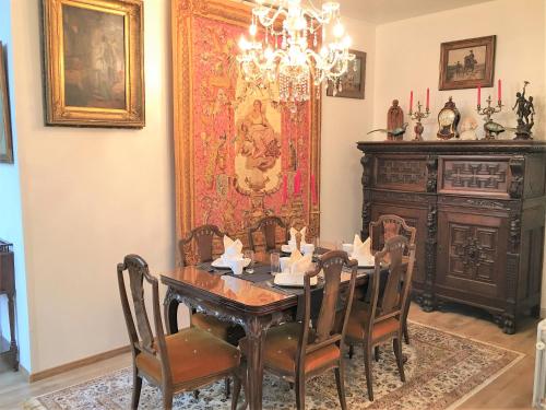 a dining room with a table and a chandelier at Koetshuis Bosdam in Beveren