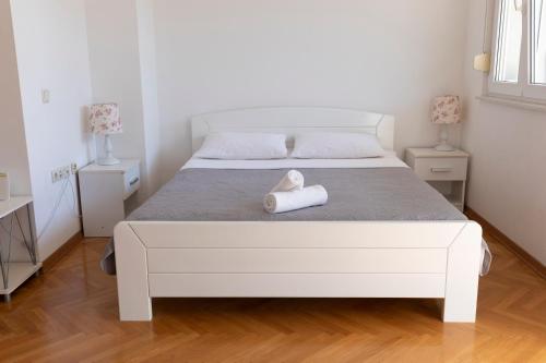 un letto bianco con un asciugamano bianco di Sorento Apartments a Dubrovnik