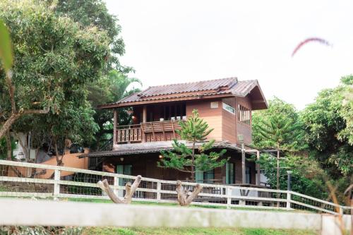 uma casa com uma cerca em frente em U Maerim Chiangmai - อยู่แม่ริม เชียงใหม่ em Mae Rim