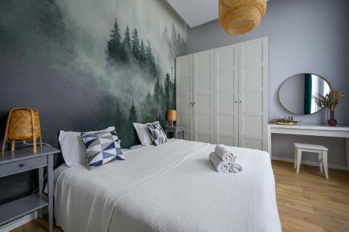 a bedroom with a large bed with a painting on the wall at Rent-Apart City Center Lodz in Łódź