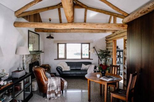 uma sala de estar com um sofá e uma mesa em Luxury Yarra Valley Vineyard Log Cabin em Yellingbo