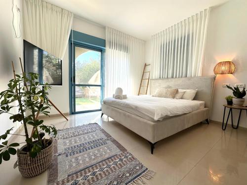 a bedroom with a bed and a potted plant at Nirvana Maayan Baruh in Ma‘yan Barukh