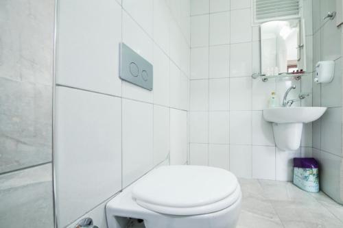 a white bathroom with a toilet and a sink at ELİSA Park Hotel in Trabzon