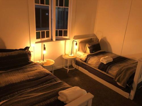 1 dormitorio con 2 camas y 2 lámparas. en Sawtell cottage. 5min to beach.Pets, en Sawtell