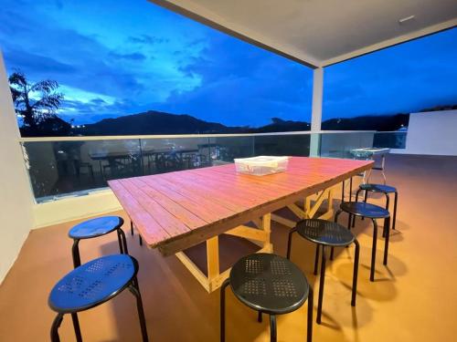 y balcón con mesa de madera y 4 sillas. en The Misty Penthouse en Tanah Rata