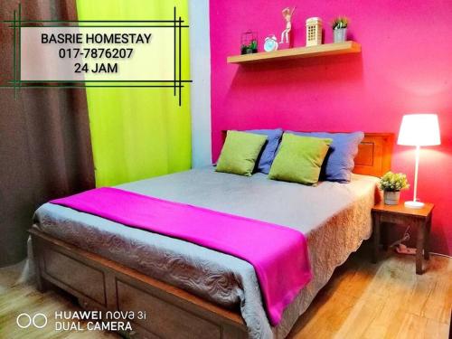 um quarto com uma cama com paredes cor-de-rosa e verde em Basrie Homestay Pagoh - Private Pool/W-ifi/NetFlix/Cozy em Pagoh