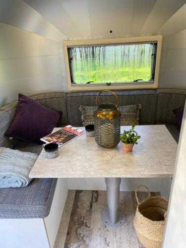 a table in a tiny house with a window at Hall Farm Hideaway in Kings Lynn