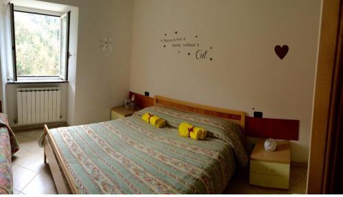 1 dormitorio con 1 cama con 2 almohadas amarillas en Affittacamere La Quiete, en Borzonasca