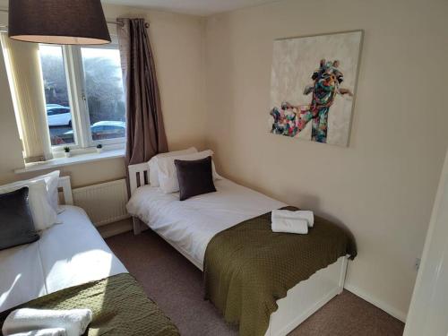 um pequeno quarto com 2 camas e uma janela em Ormonde Close 3 bed contractor family home Grantham em Grantham