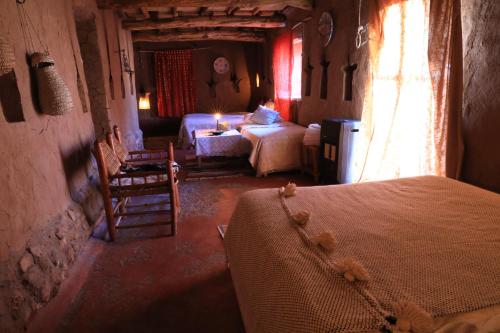 a bedroom with a bed and a room with two beds at Kasbah Tebi in Aït Ben Haddou