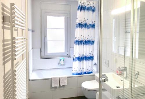 een badkamer met een toilet, een wastafel en een raam bij La Casa - comfortable - by PA in Luzern