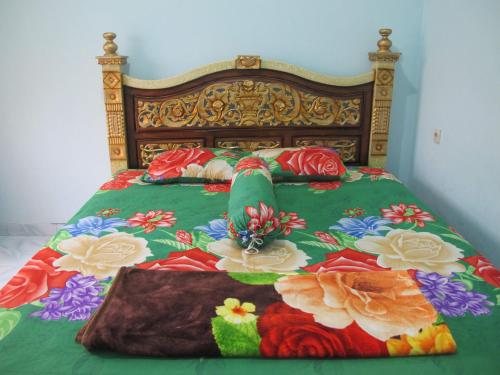 a bed with a colorful bedspread with flowers on it at MOANA INN in Karimunjawa